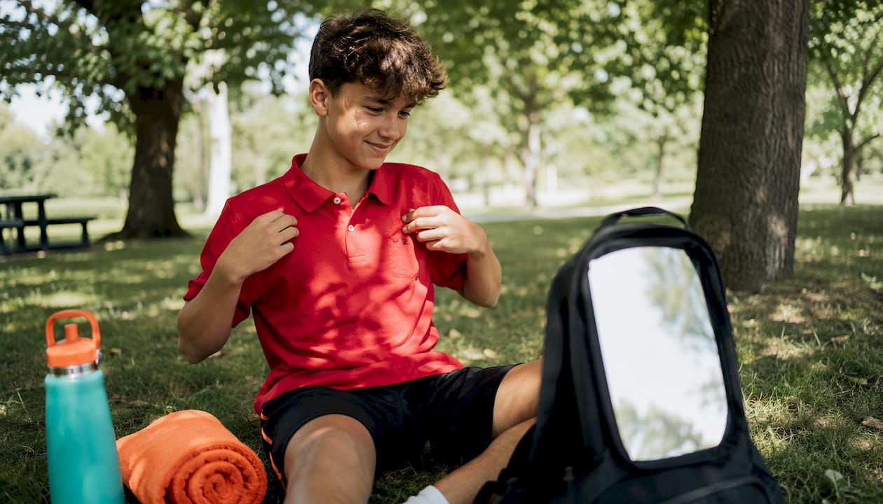 Teen boy trying embroidered sports polo in fitting room