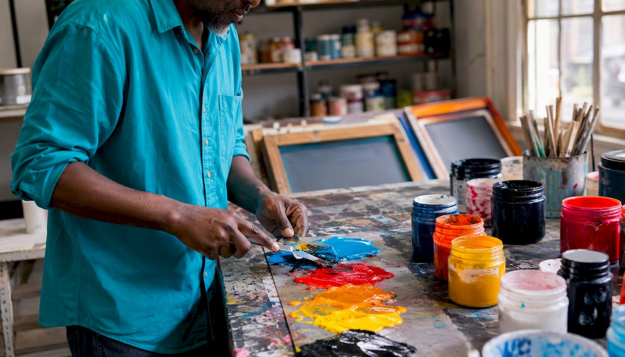 Hands preparing screen printing setup