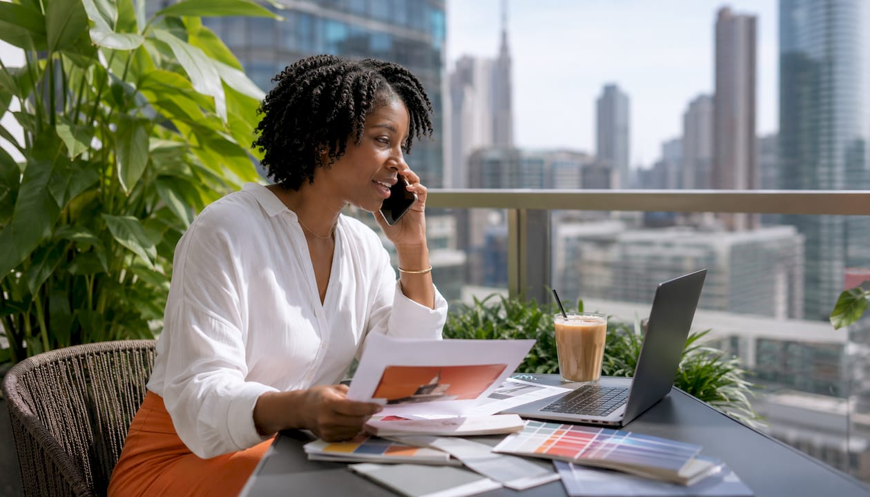 Woman discussing print proofs on phone in office