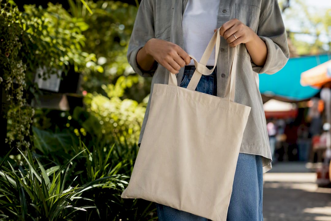 Hands holding folded canvas tote bag
