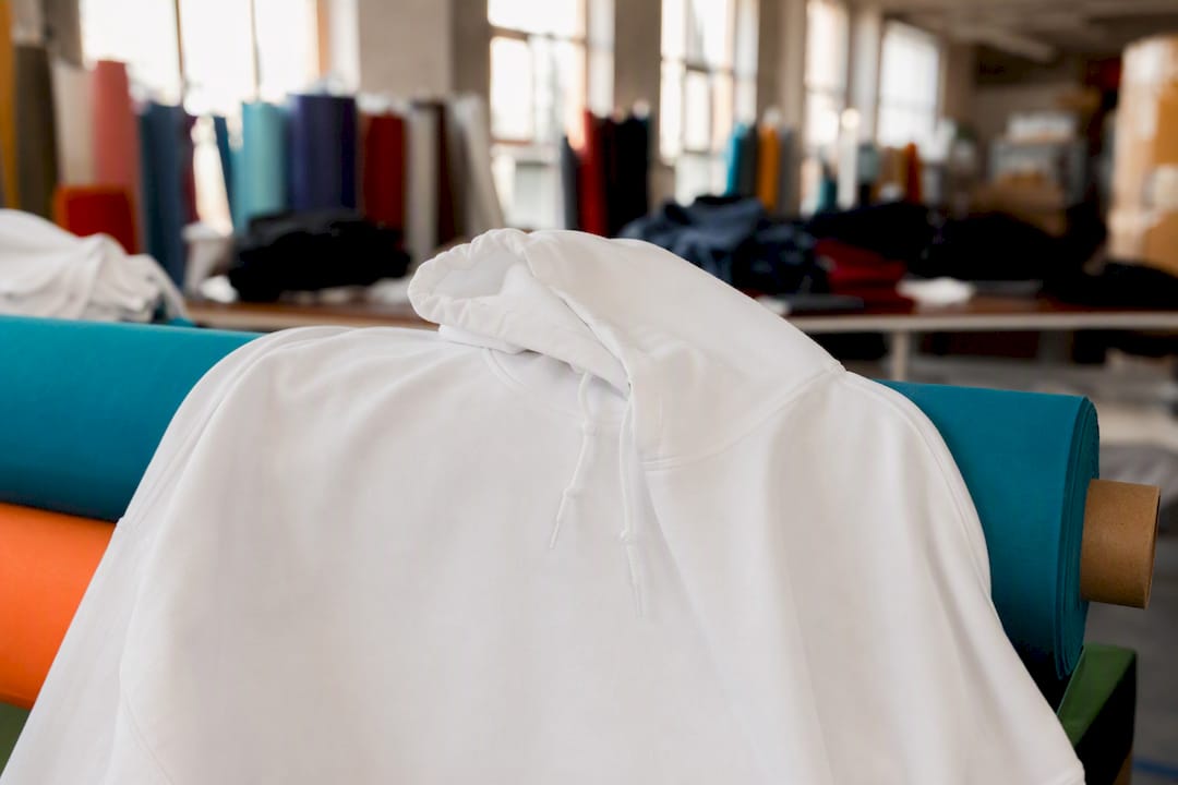Unbranded white hoodie on rack close-up