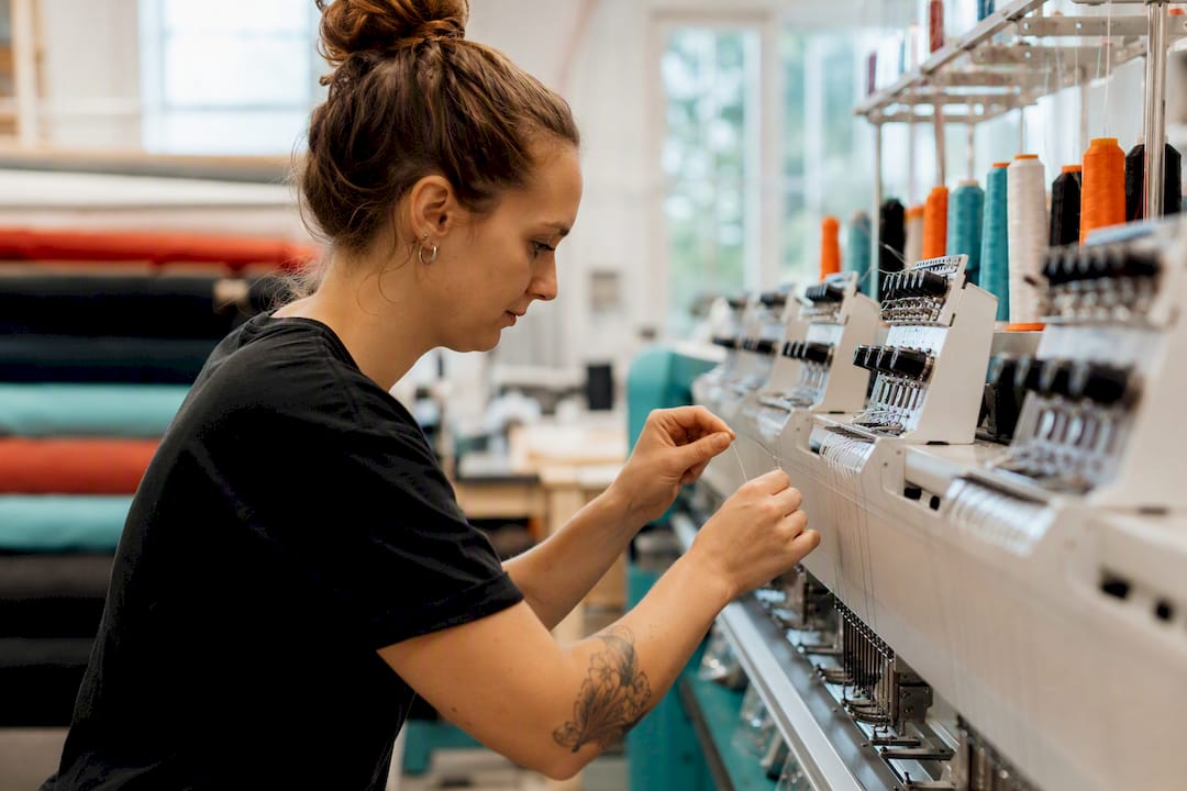 Hands threading embroidery machine needle