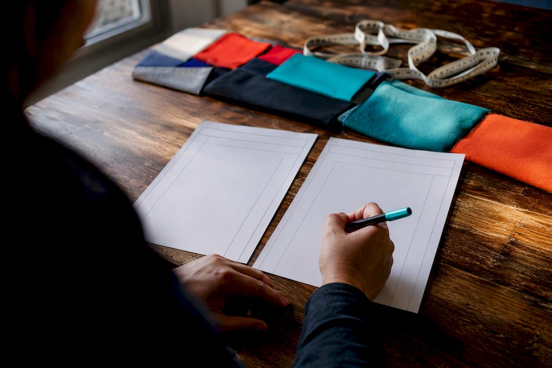 Hands comparing custom apparel quote sheets