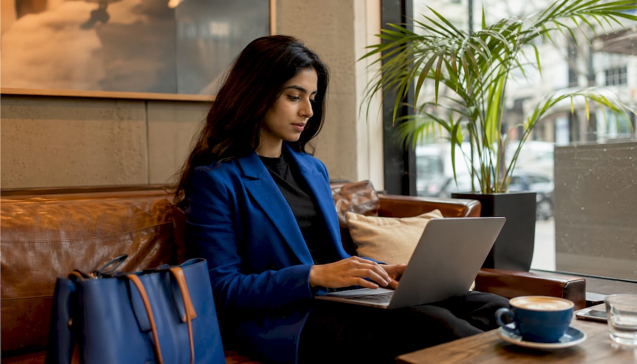 Hands typing on laptop in coworking space