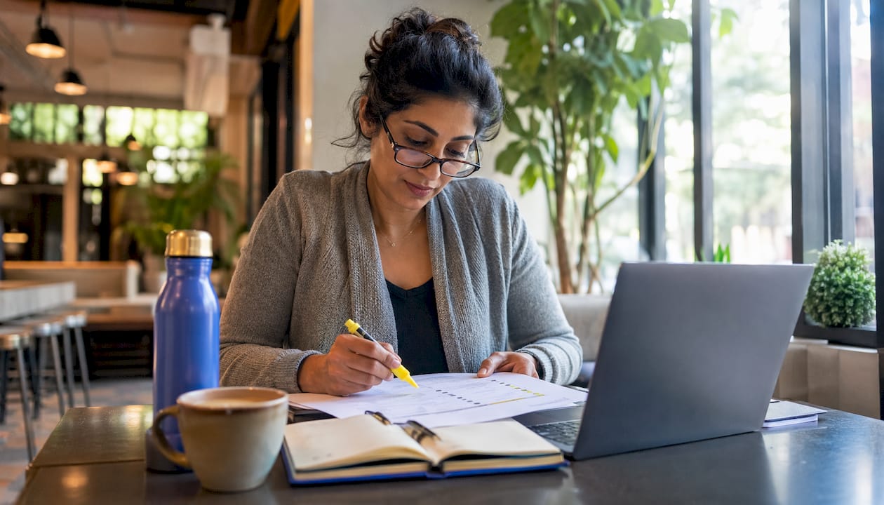 Woman reviewing career transition timeline at home desk