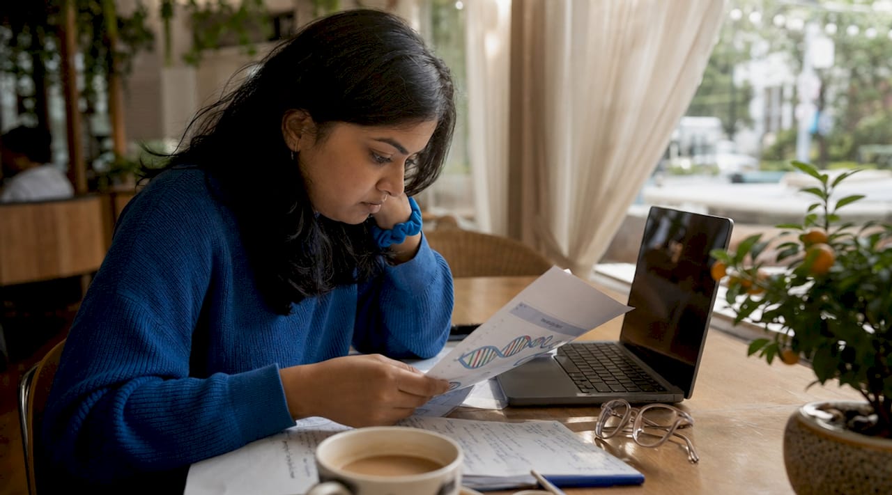 Woman reviewing DNA test report at home table