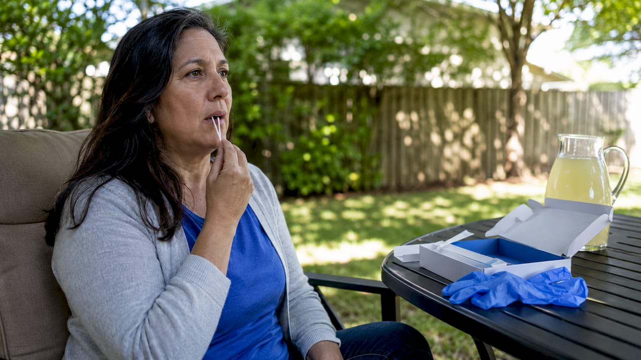 Woman collecting DNA sample at kitchen table