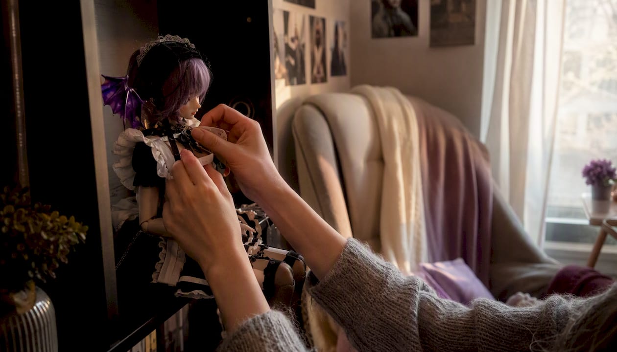 Hands adjusting wig on a lifelike doll at home