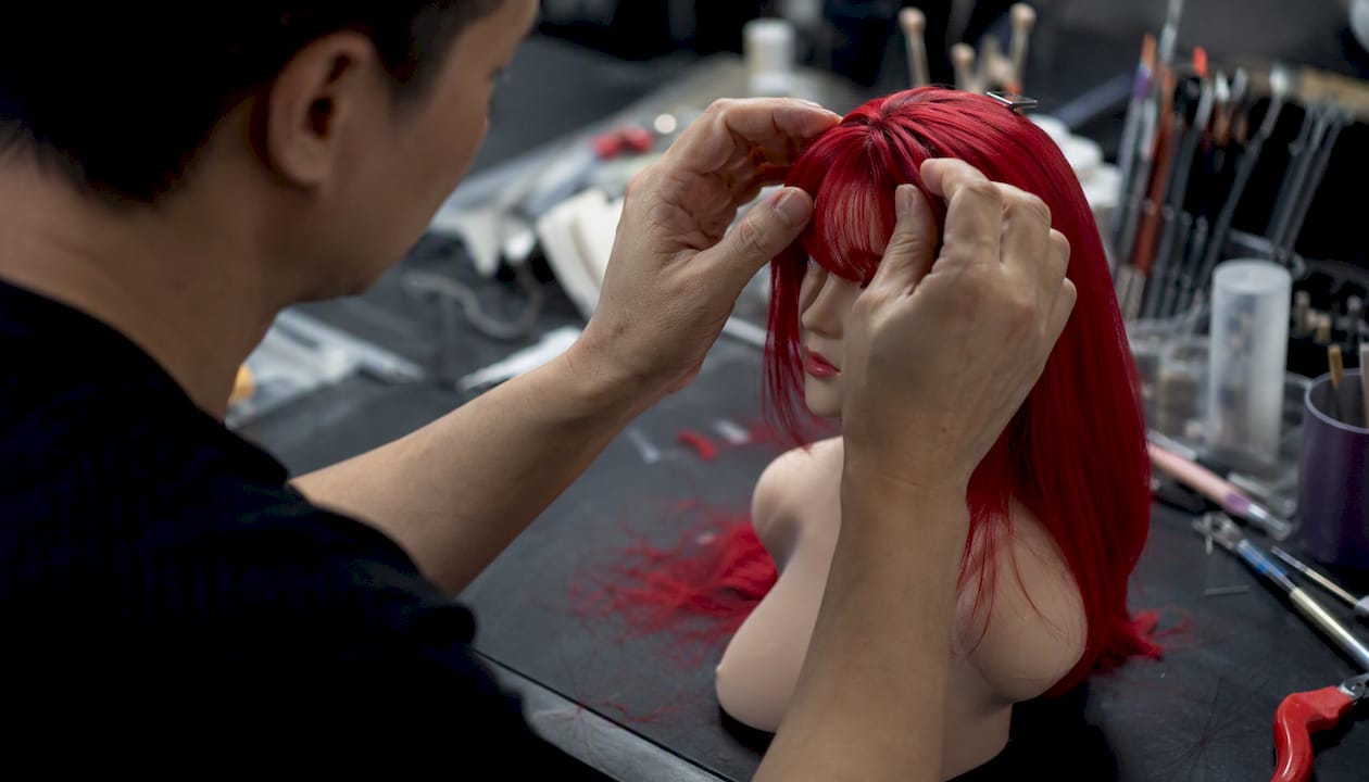 Hands adjusting doll hair in production