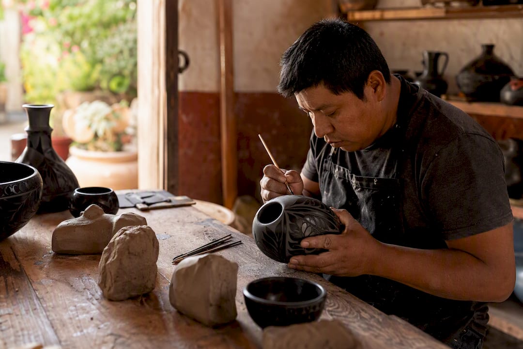 Hands shaping colorful barro negro pottery