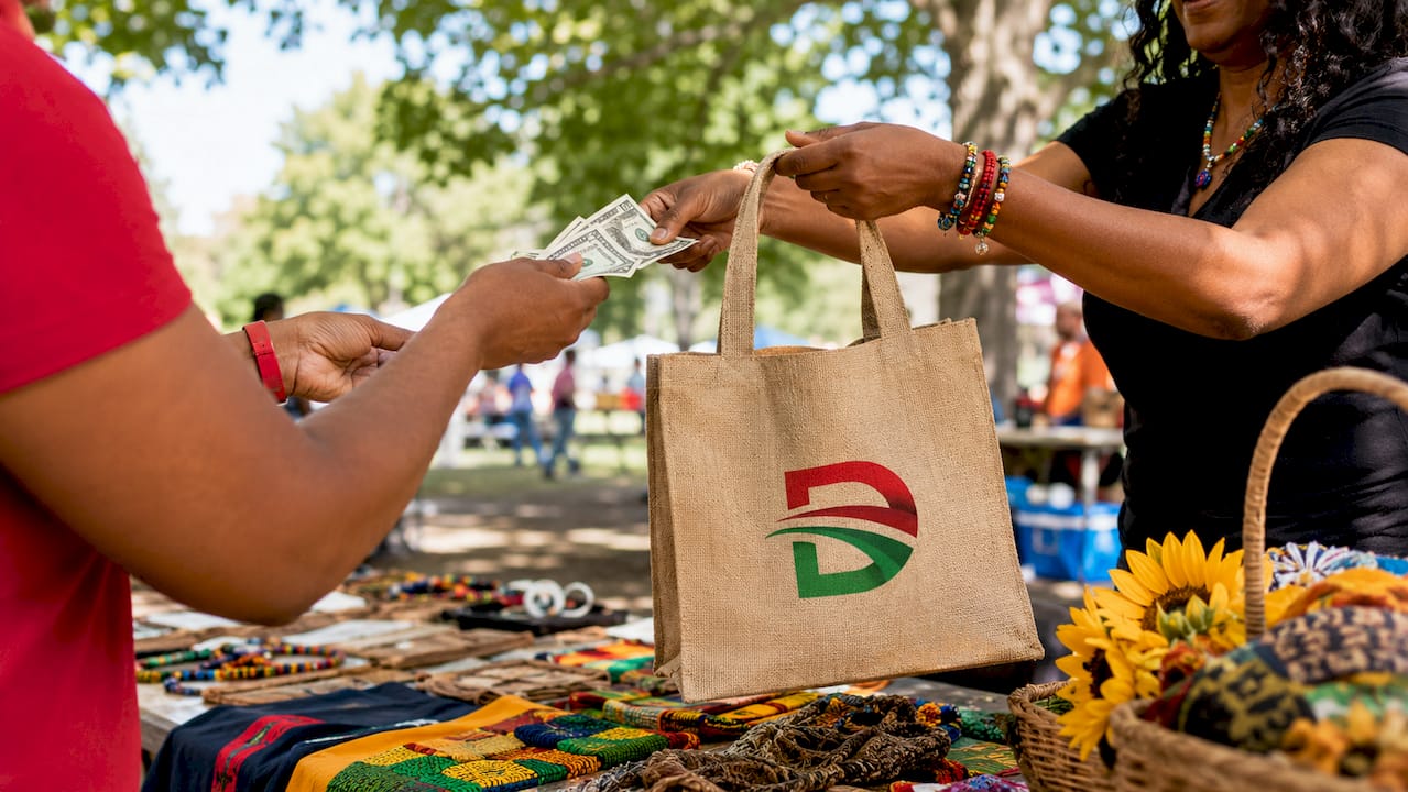 Hands exchanging payment and bag at marketplace