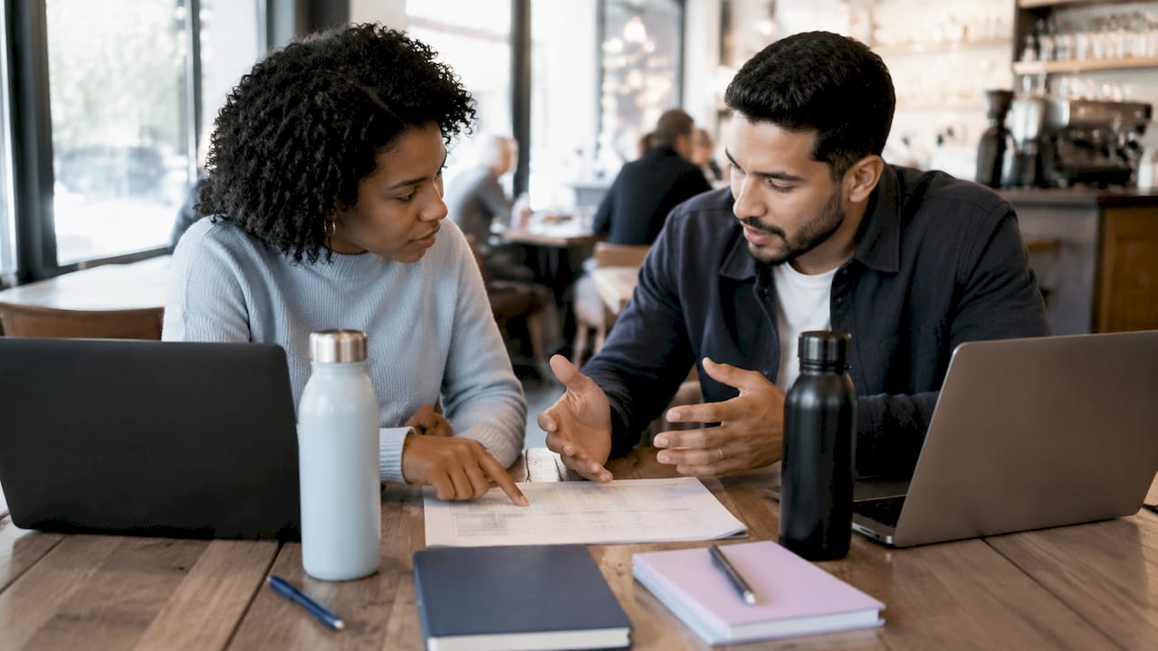Two colleagues reviewing database features at table