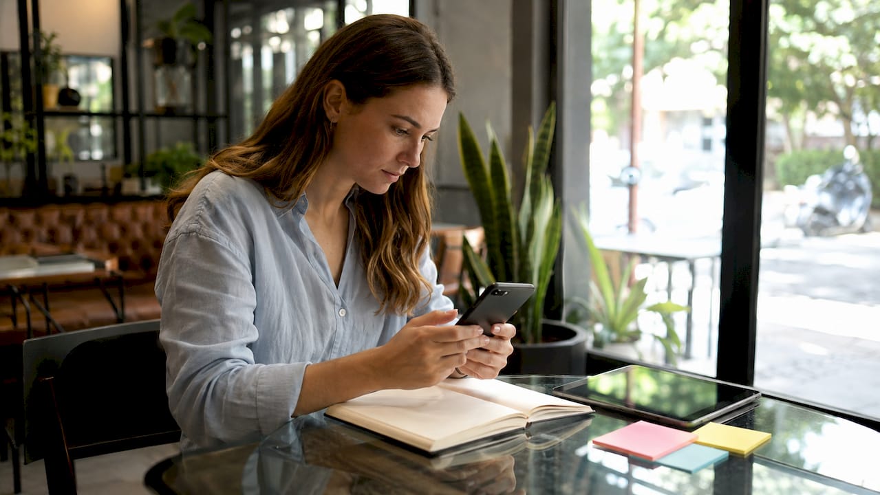Hands testing app on smartphone in meeting room