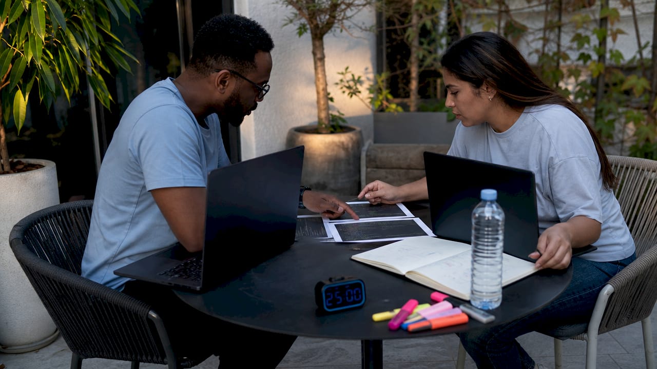 Developers comparing Flutter and React code printouts