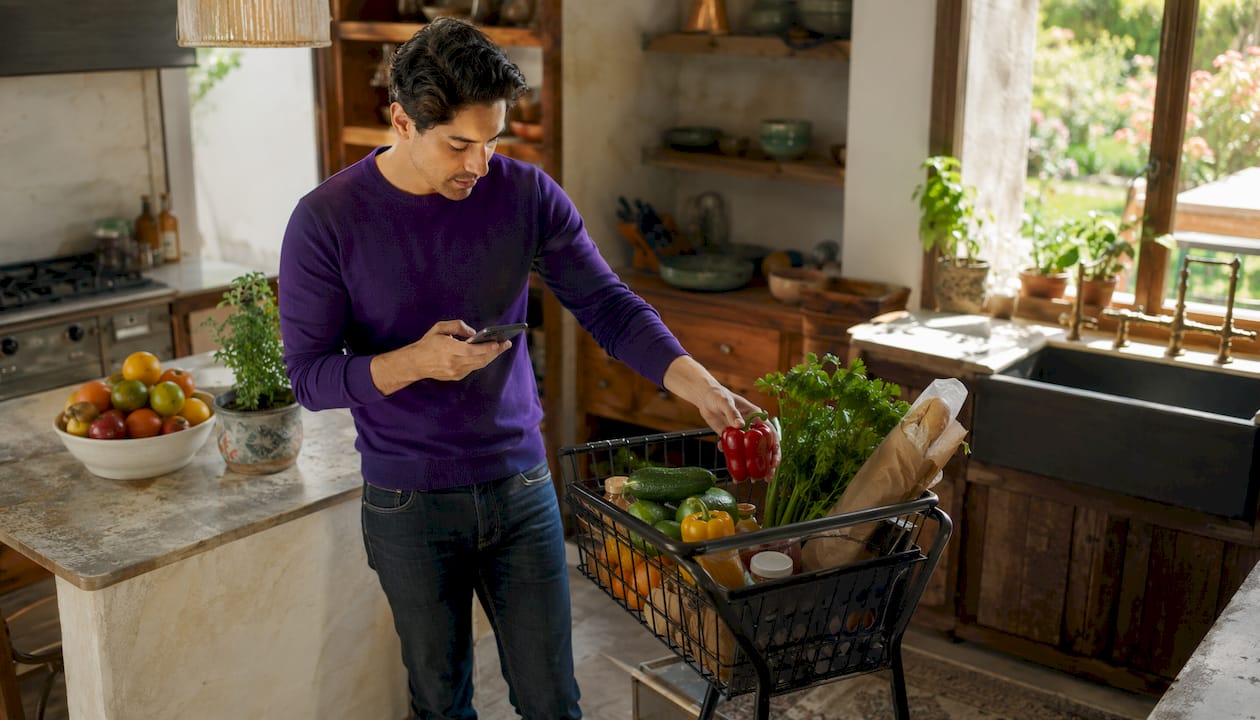 Shopper ordering groceries online with cart