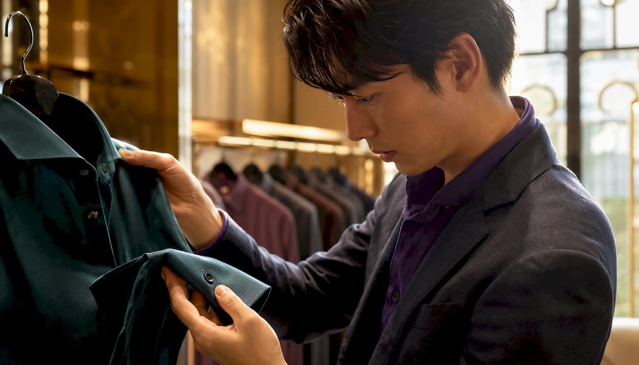 Man assessing shirt fabric softness and fit