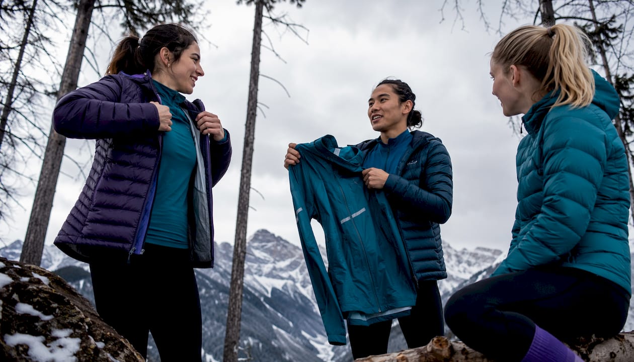 Group discussing layered sportswear outdoors in winter