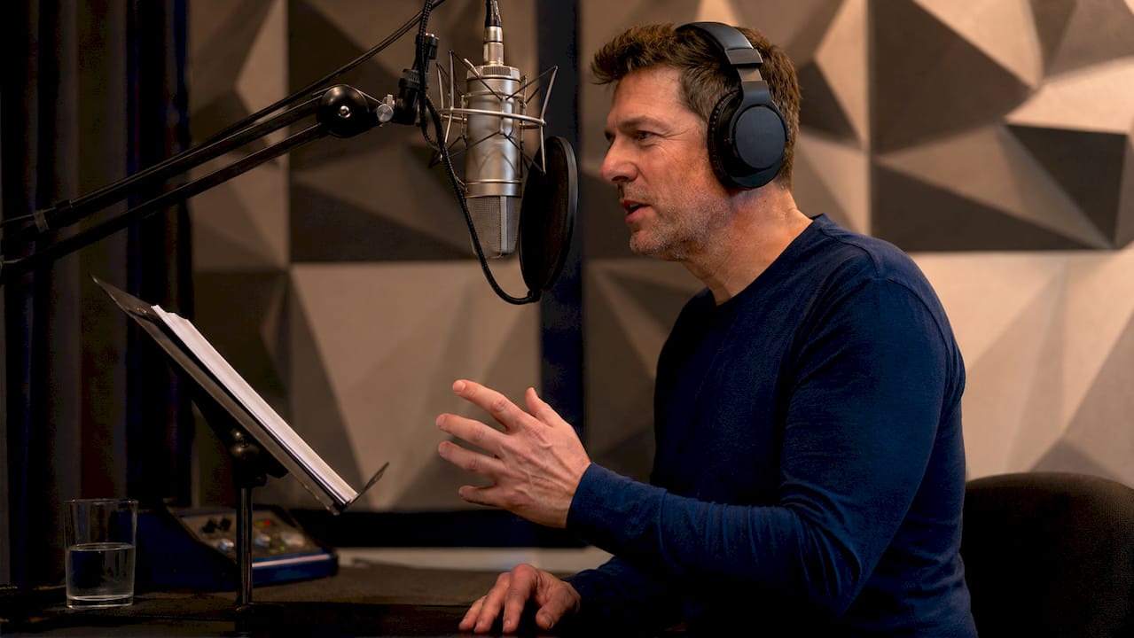 Narrator recording voiceover in sound booth