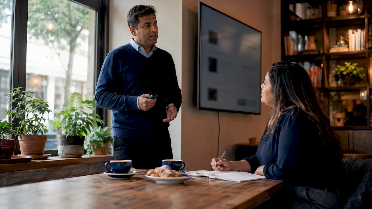 Man narrating and presenting sales slides to colleague