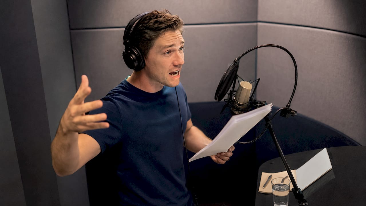Voice actor performing in recording booth