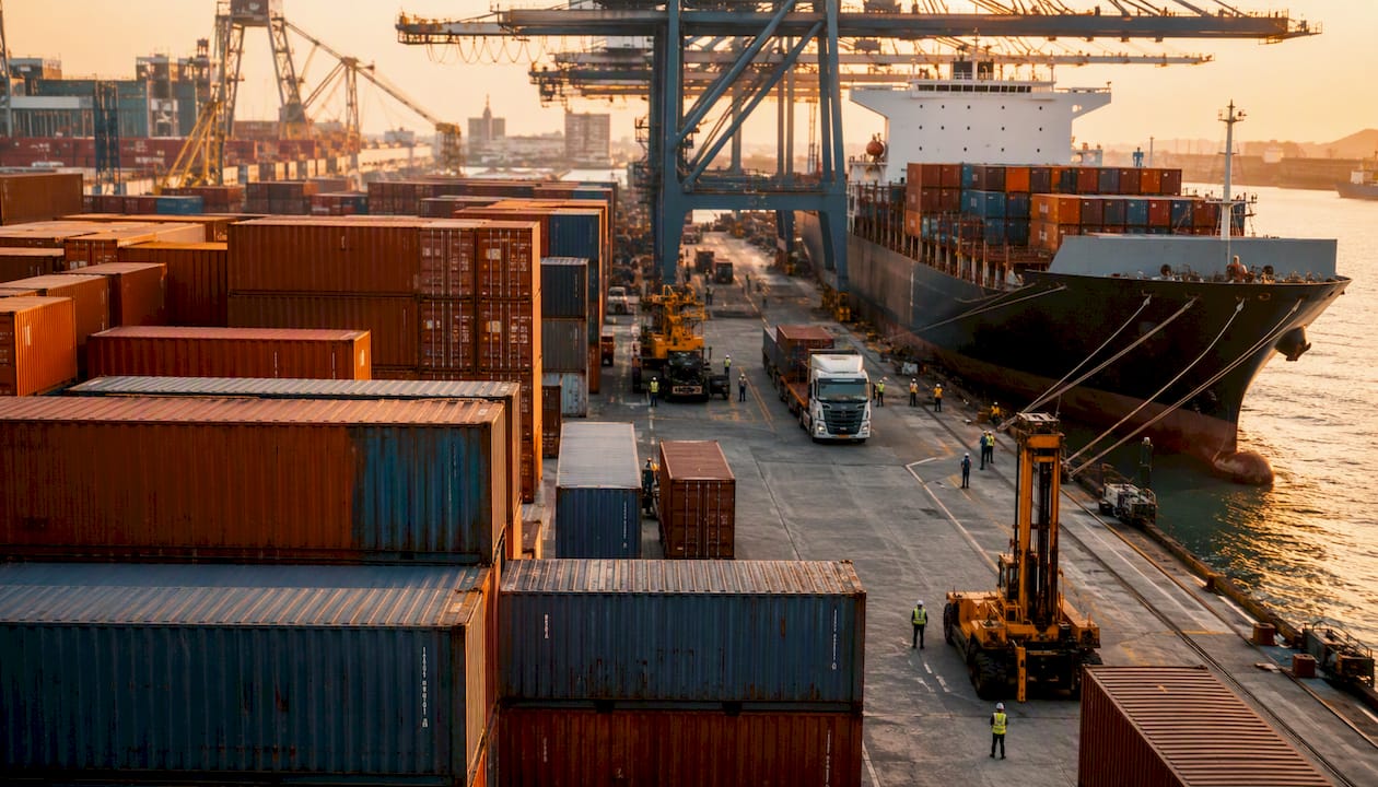 Workers climbing and locking containers at port dock