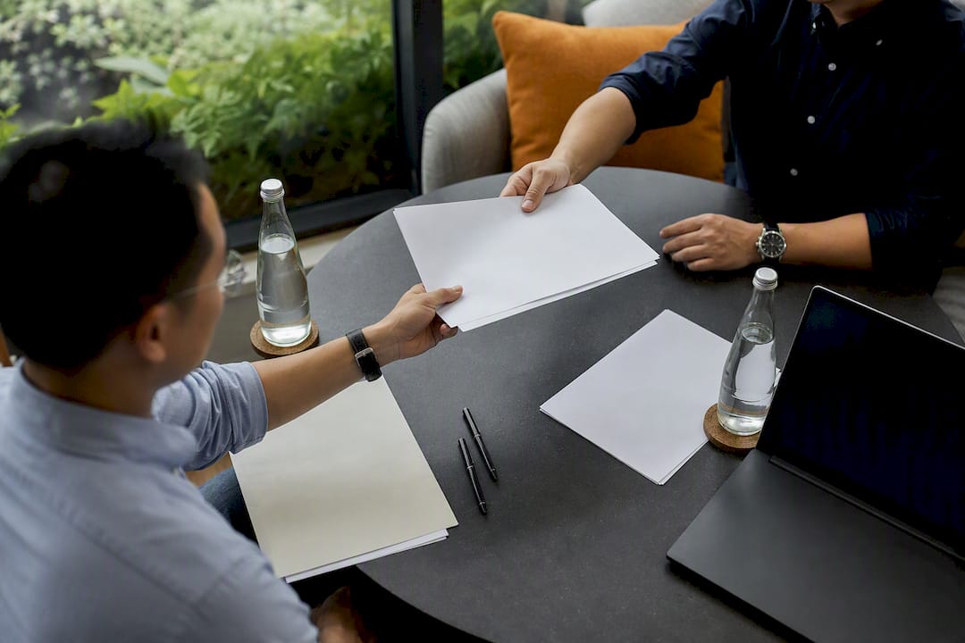 Hands exchanging documents in trade negotiations
