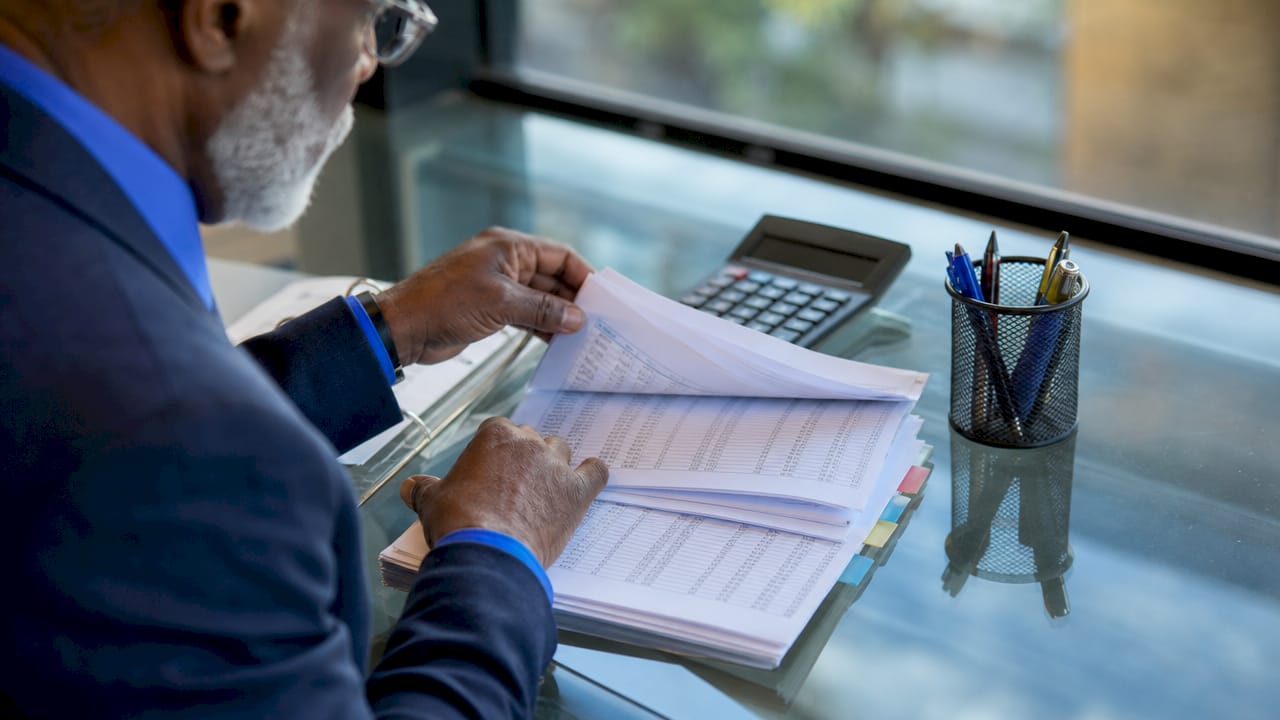 Hands reviewing financial audit logs