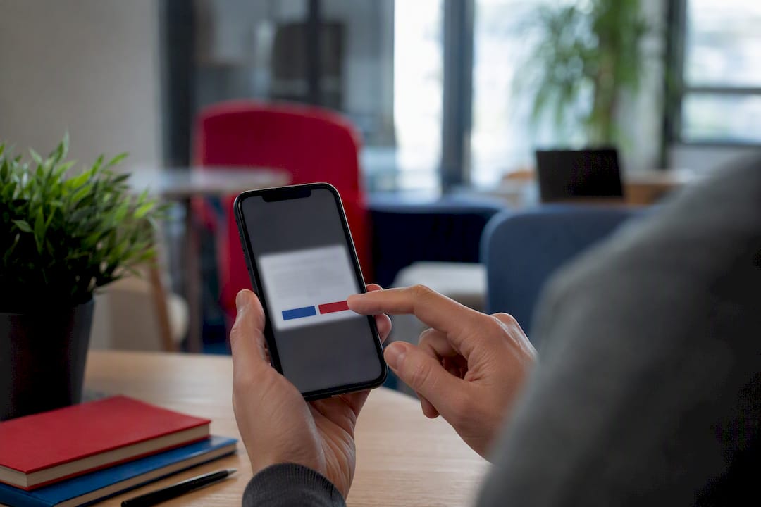 Hand poised over smartphone with cookie consent banner