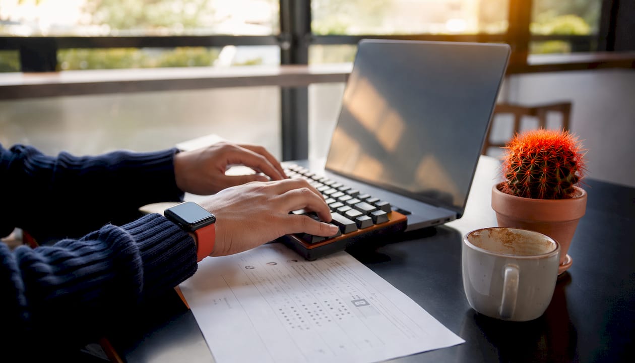 Hands typing candidate scoring on laptop keyboard