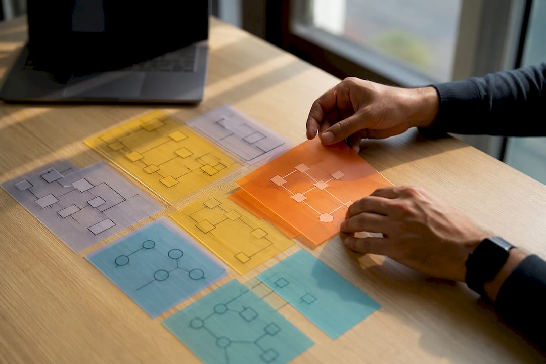 Hands arranging enterprise architecture diagram overlays