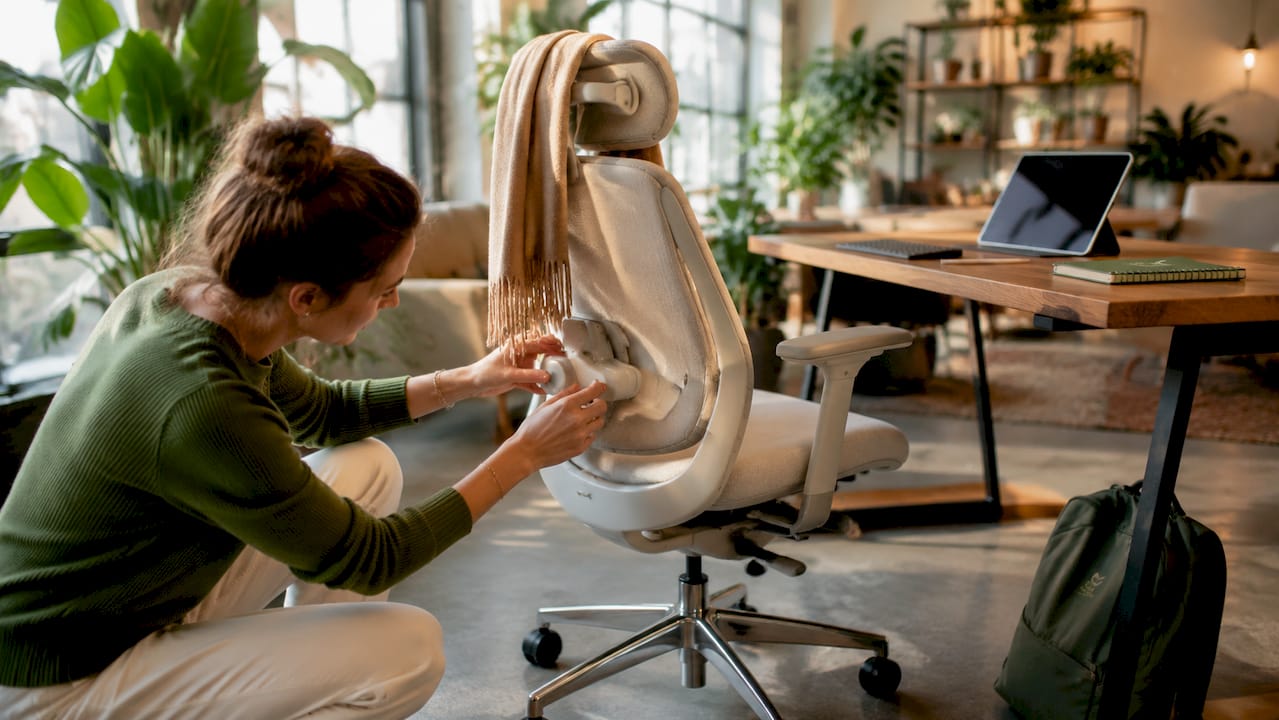 Hands adjusting ergonomic office chair lumbar support knob