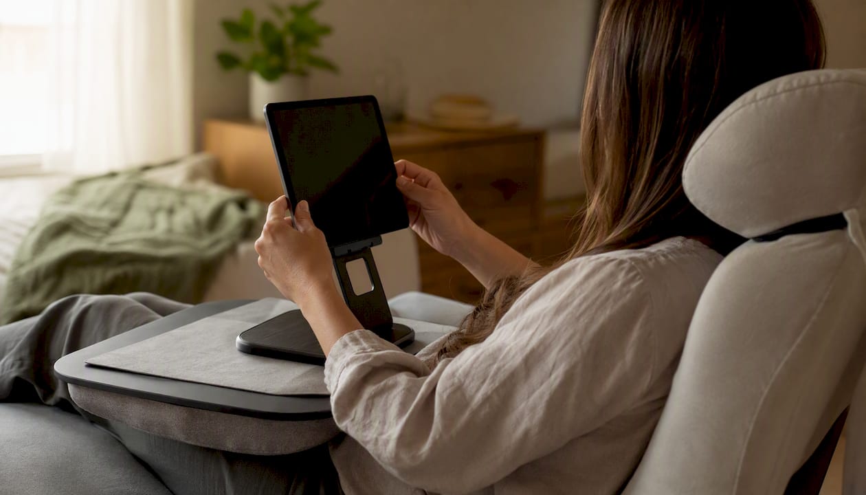 Hands adjusting tablet on stand with headrest support