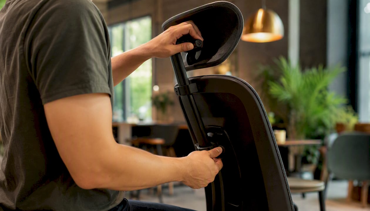 Hands adjusting ergonomic chair armrest and seat depth