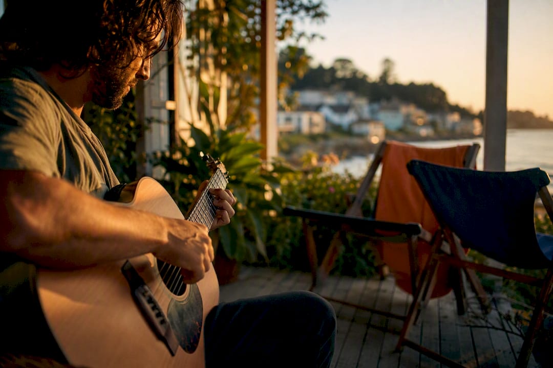 Hand strumming guitar at porch music event