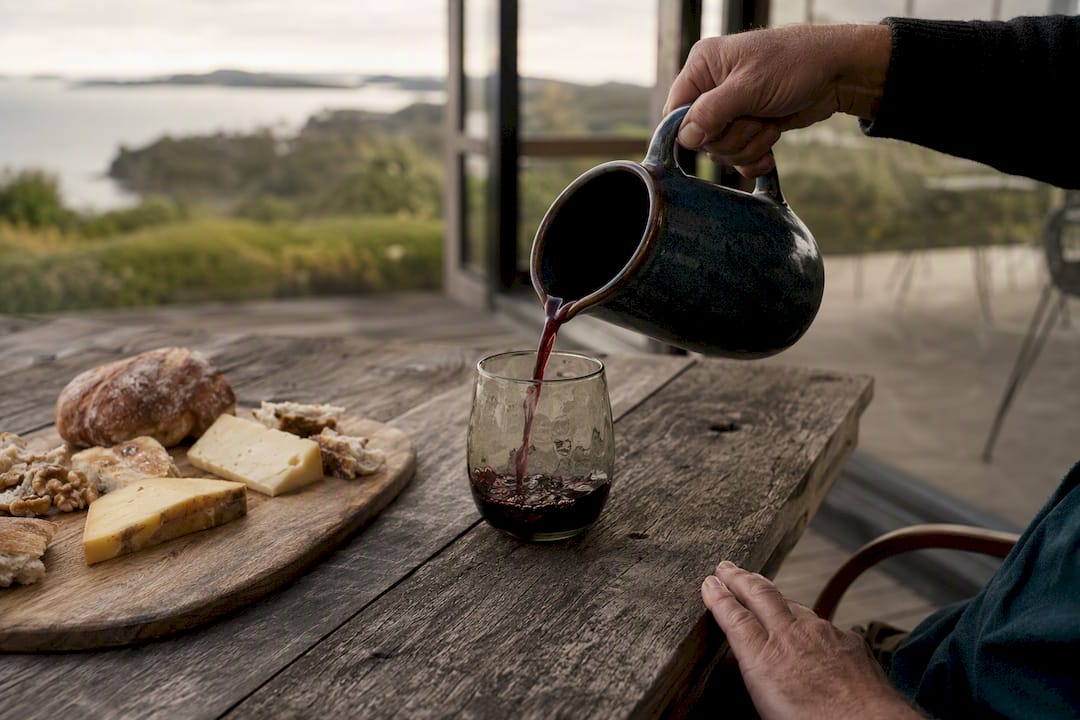 Pouring red wine indoors on Waiheke in winter