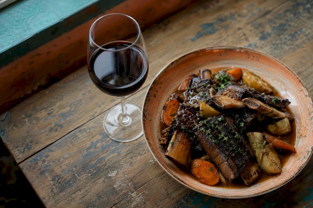 Glass of Syrah wine with hearty winter meal