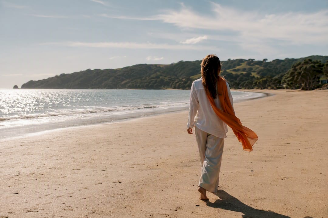 Visitor walking along Onetangi Beach