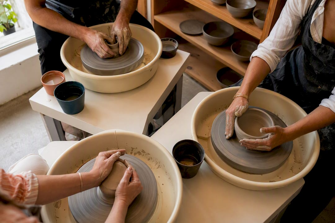 Hands shaping clay during pottery class