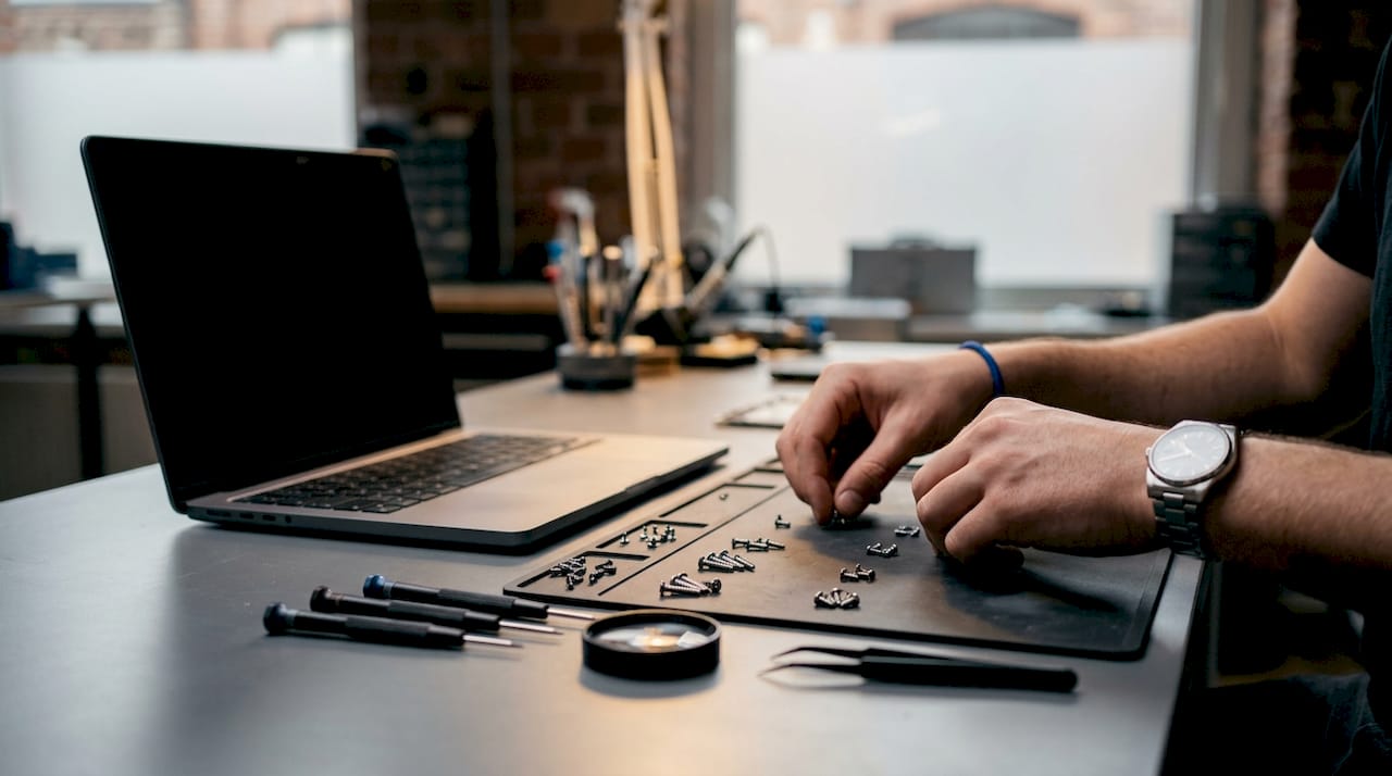 Hands organizing screws during device repair
