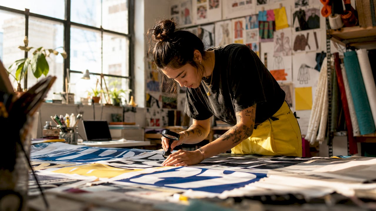 Apparel designer reviewing typography fabric swatches in studio