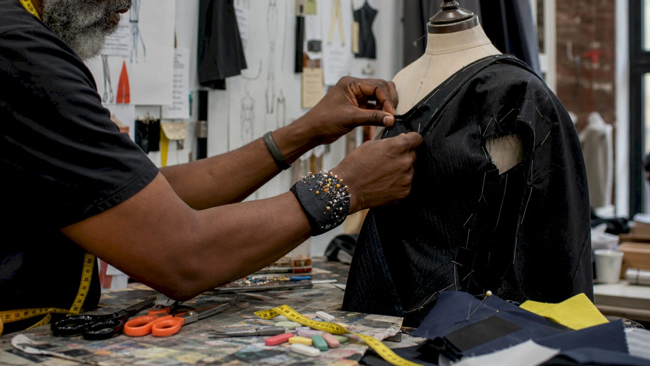 Tailor adjusting garment on dress form overhead view