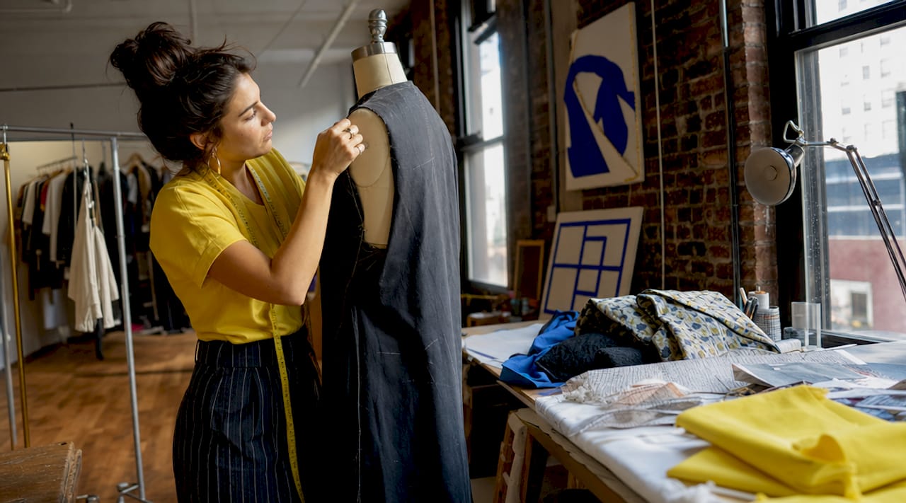 Fashion designer reviewing sample garment in NYC studio