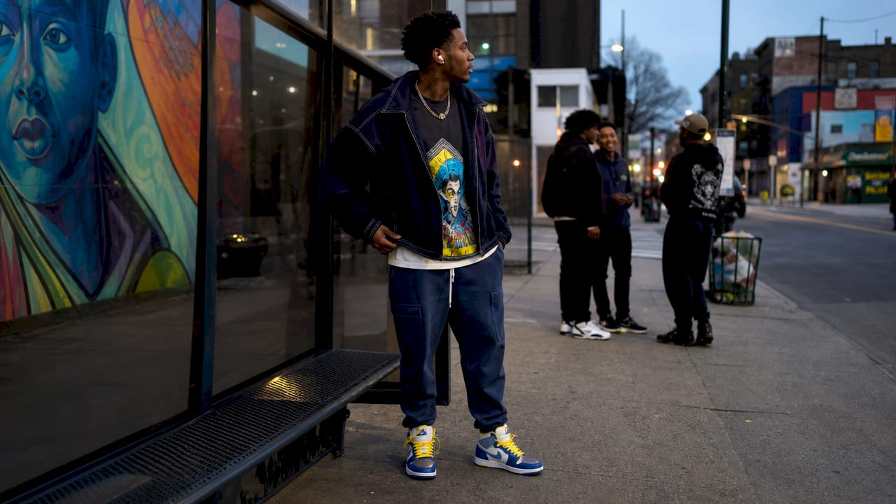 Young man in layered NYC streetwear on busy street