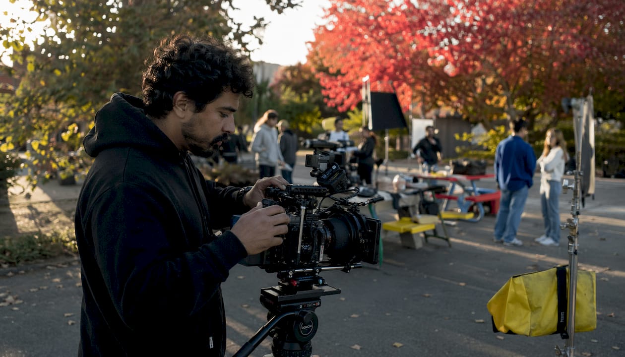 Cinematographer adjusting TV camera on set