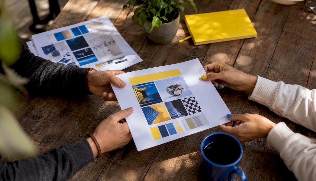 Hands exchanging brand strategy briefs over table