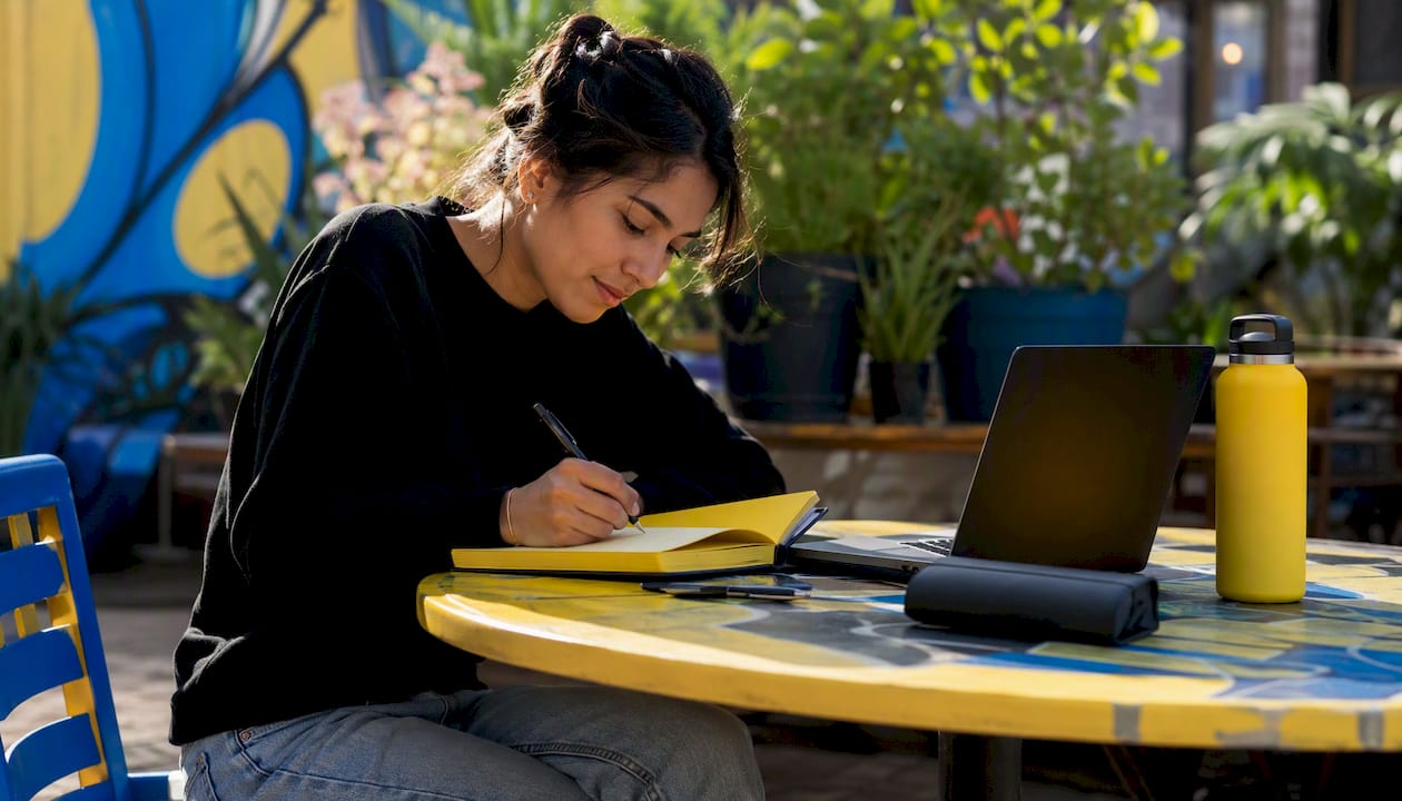 Woman writing content ideas at home studio desk