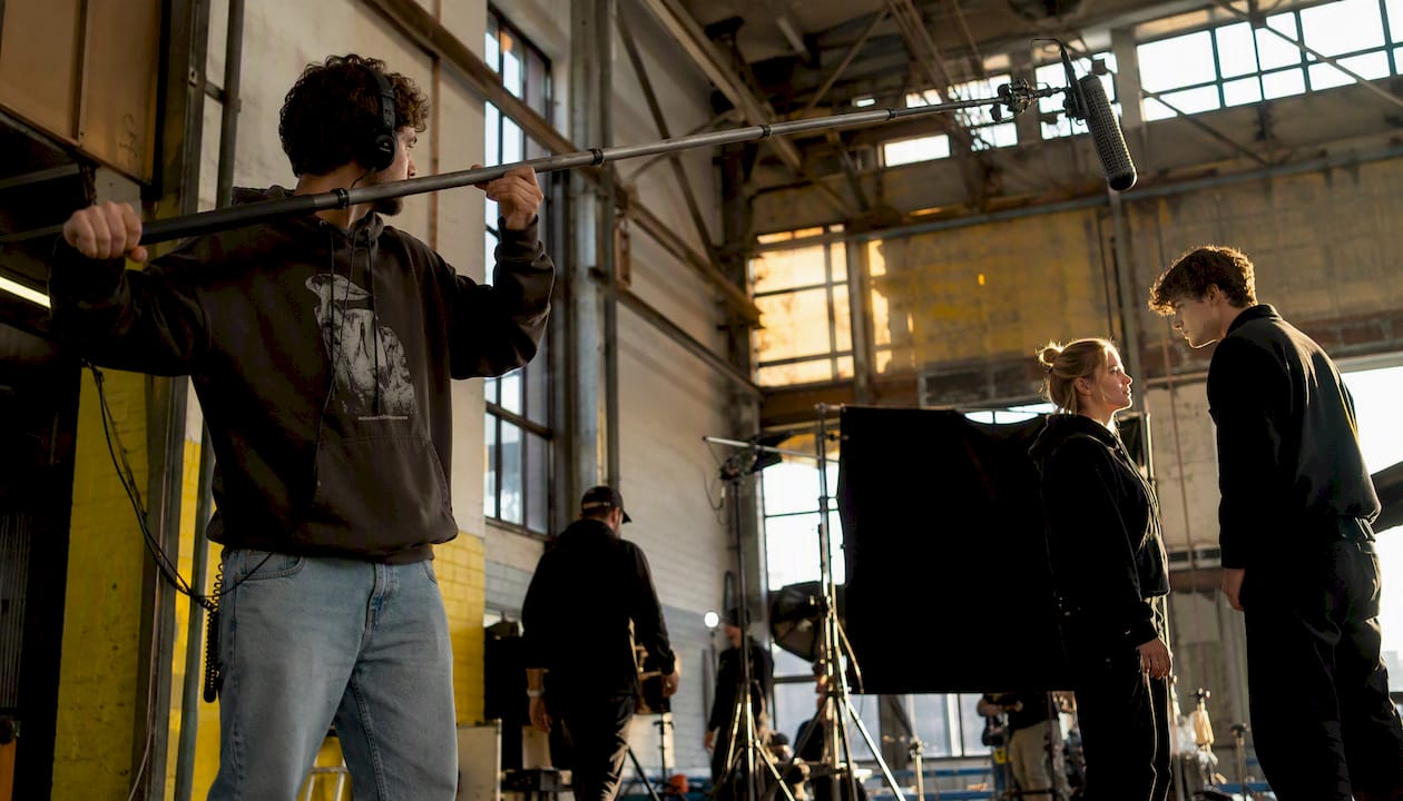 Boom operator holding mic on film set