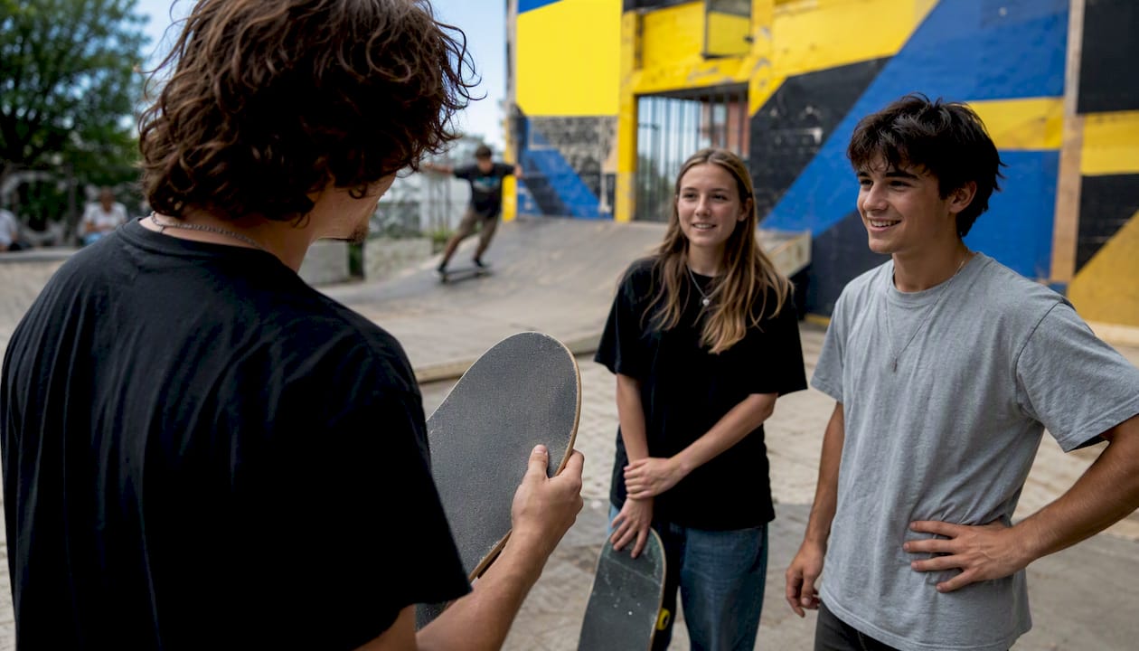 Founder holding skateboard deck at urban skate park