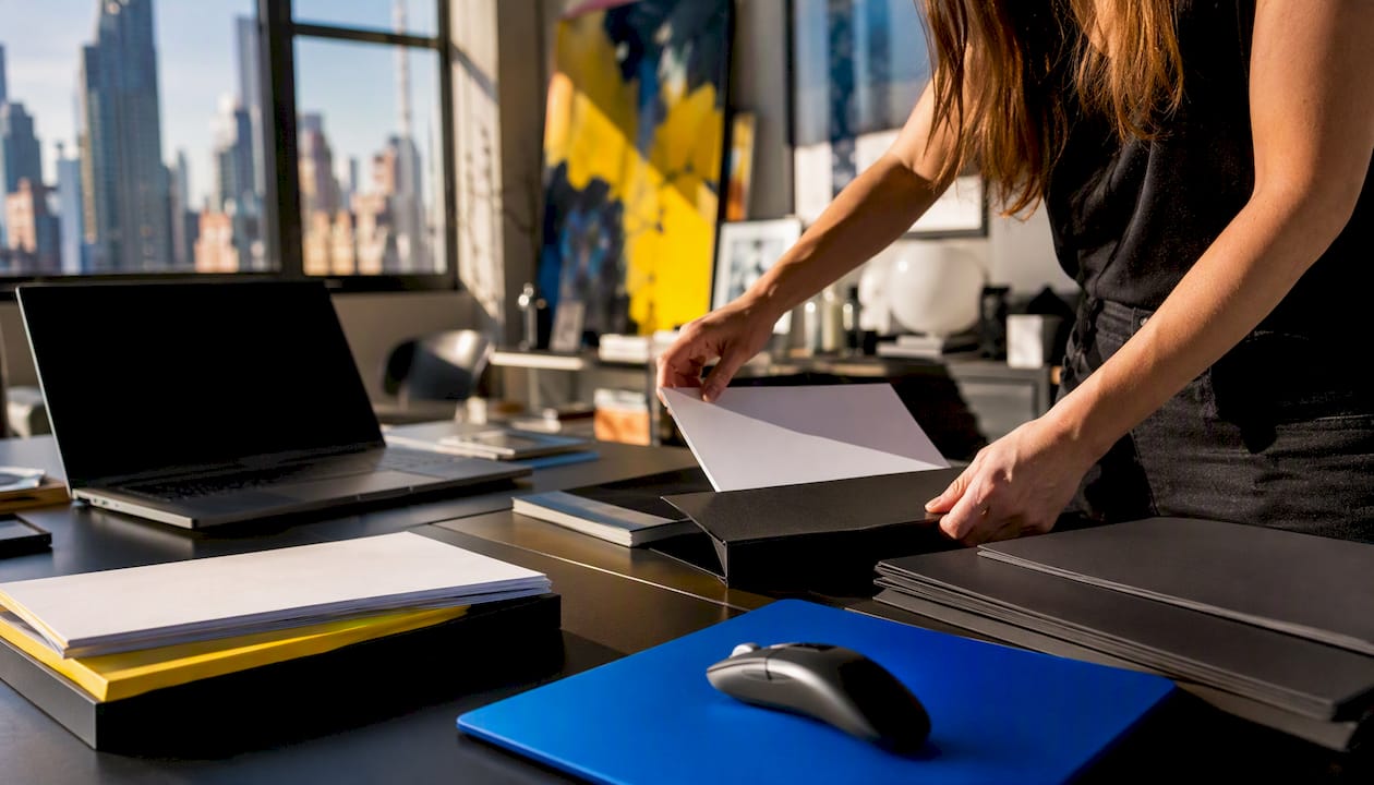 Hands preparing client onboarding materials