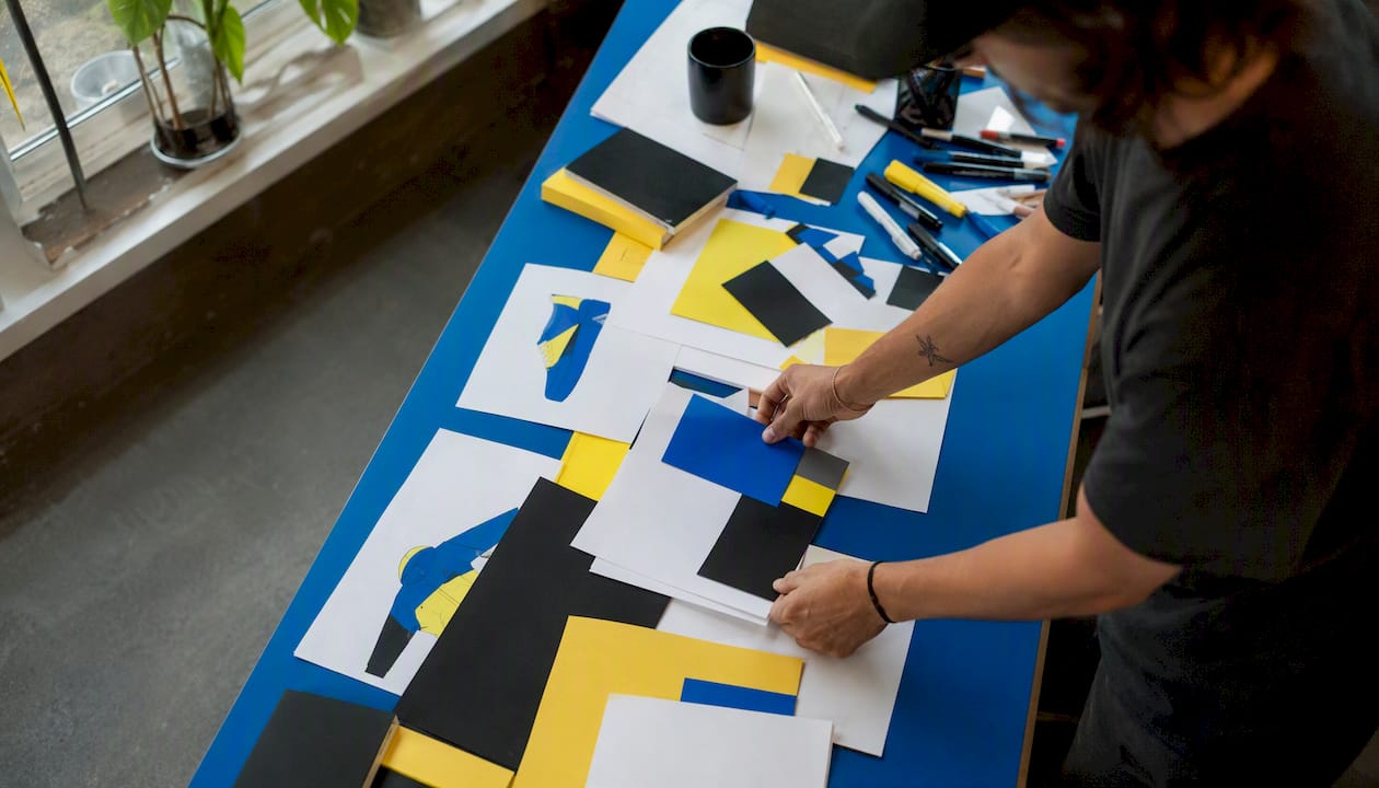 Hands arranging colorful brand assets on table